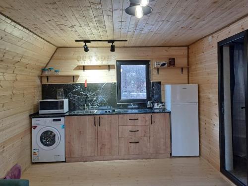 una cucina con lavatrice, lavandino e frigorifero di Panorama cottages in Sno a Sno