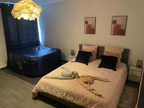 1 dormitorio con 1 cama, 1 maleta y 1 lámpara de araña en Domaine des mirages, en Mas-Saintes-Puelles