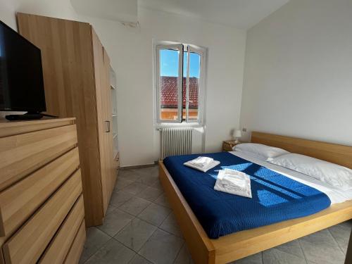 une chambre avec un lit avec des draps bleus et une télévision dans l'établissement Sant'Andrea Appartamento nel borgo antico, à Levanto