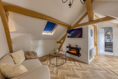 een woonkamer met een bank en een open haard bij Romantique love room / 15mn Fontainebleau in Montereau-faut-Yonne