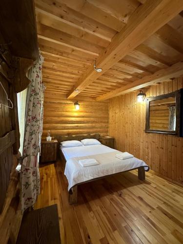 a bedroom with a bed in a wooden room at База відпочинку ШИПОВЕЦЬ in Poroškov