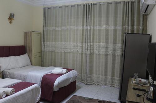 a hotel room with two beds and a curtain at pyramita luxury hotel in ‘Ezbet `Abd el-Ḥamîd