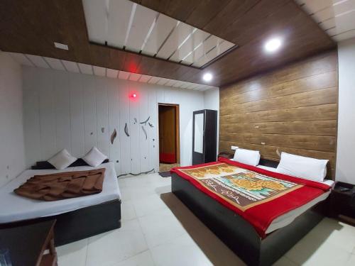 una camera con 2 letti e una parete in legno di Hotel Neelam Raj Nainital Near Mall Road - Excellent Service Awarded - Near Lake a Nainital