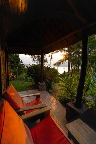 a porch with a couch and a table and chairs at Hotel Bambu in Santiago Atitlán