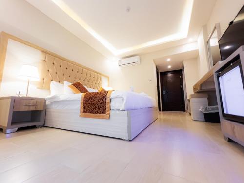 a bedroom with a bed and a flat screen tv at Petra Premium Hotel in Wadi Musa