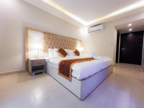 a bedroom with a large bed and a night stand at Petra Premium Hotel in Wadi Musa