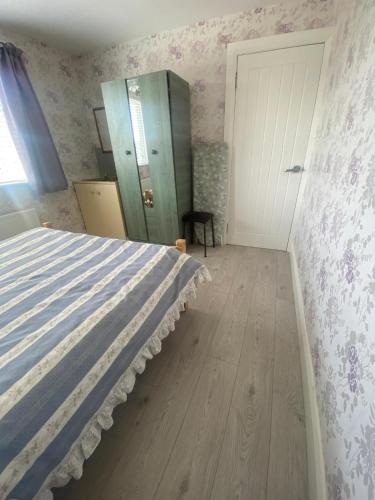 a bedroom with a bed and a dresser and a door at Ceecliff flat in Culdaff