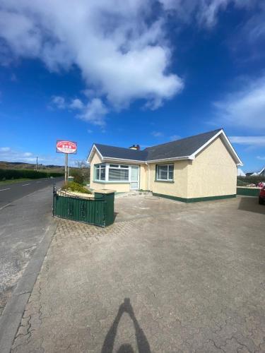 a house with a sign in a driveway at Ceecliff flat in Culdaff