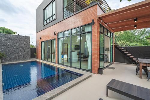 a house with a swimming pool in front of it at Aleenta Hua Hin - Pranburi - The Small Luxury Hotels of the World in Pran Buri