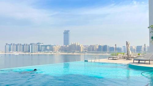 a person in a swimming pool with a view of a city at Sea Breeze Oasis in Dubai