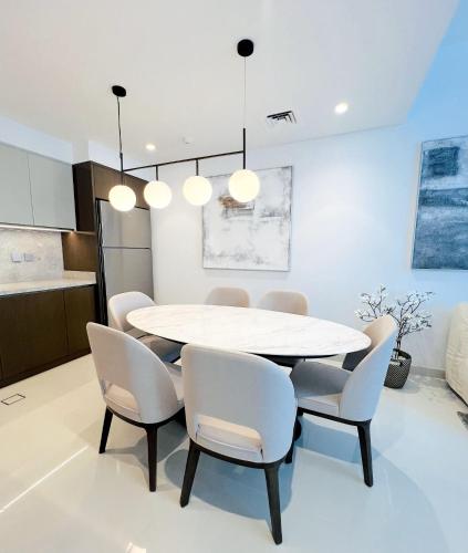 a dining room with a white table and chairs at Sea Breeze Oasis in Dubai