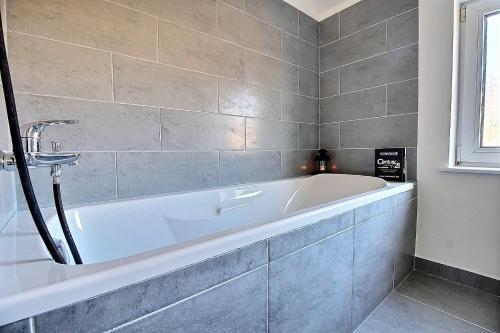 een badkamer met een wit bad en een wastafel bij Charleville 39 K Bruxelles-charleroi-aéroport in Charleroi