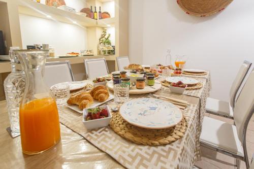 Montellino's Suite Oro في سانت أونتيوكو: طاولة عليها طعام للإفطار وعصير البرتقال