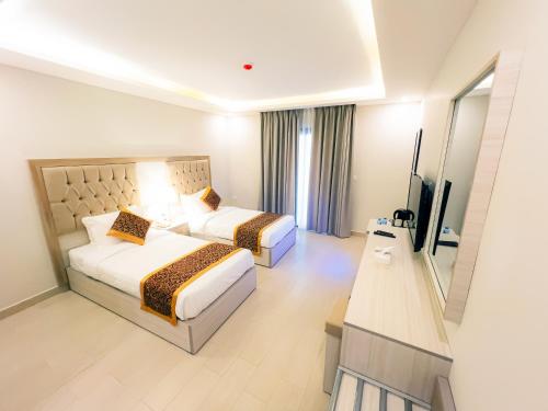 a hotel room with two beds and a television at Petra Premium Hotel in Wadi Musa