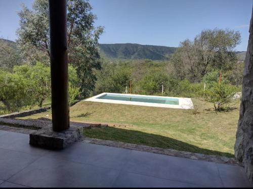 uitzicht op een zwembad vanaf het balkon van een huis bij Cabaña de piedra Los Crespines in San Antonio de Arredondo