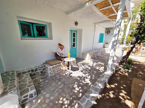 a man sitting on a porch of a house at Lemon Nest in Marathokampos