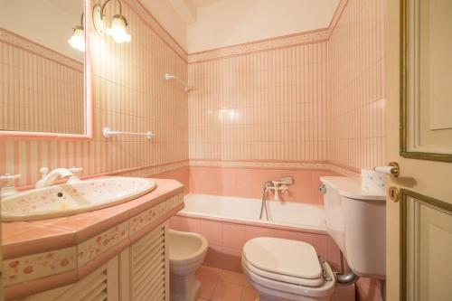 a pink bathroom with a sink and a toilet and a tub at Villa Carla, a charming villa in the center of Taormina in Taormina