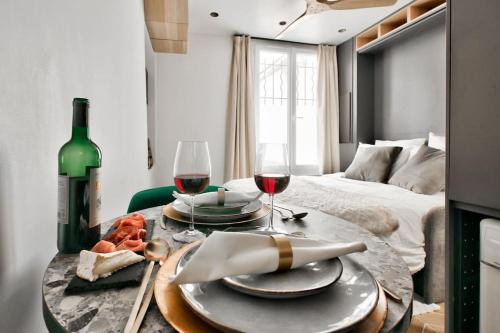 - une table avec deux verres de vin et un lit dans l'établissement NEW ! Cosy Suite Intimate Nest Sacré Coeur Paris !, à Paris