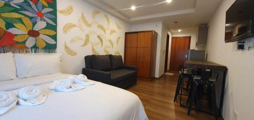 a hotel room with a bed and a chair at JCGA Apartments at Megatower Residences IV - Near SM & Session Rd in Baguio