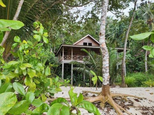 uma casa no meio de uma floresta de árvores em Sunset Surf Villas em Tua Pejat