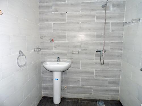 a bathroom with a sink and a shower at Résidence Les Oliviers by Jad Inn in Nouakchott