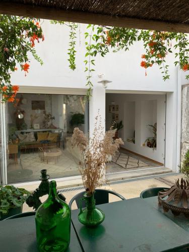 a table with two green vases on top of it at Farmacia Beach House in Odemira