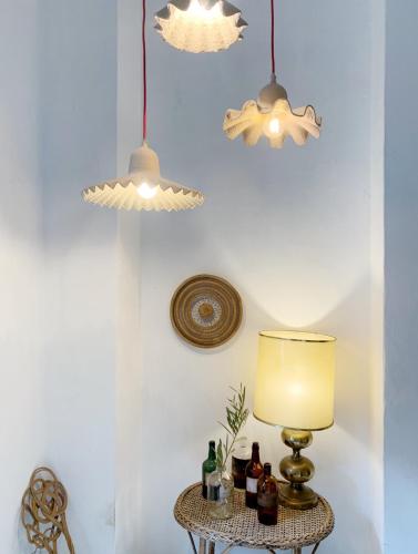 a table with a lamp and some bottles on it at Farmacia Beach House in Odemira