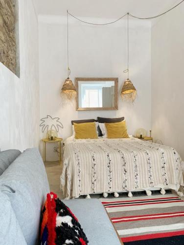 a bedroom with a bed with yellow pillows and a mirror at Farmacia Beach House in Odemira