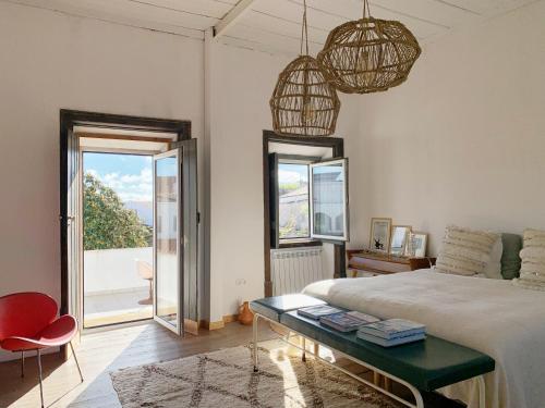 1 dormitorio con cama, mesa y ventana en Farmacia Beach House, en Odemira