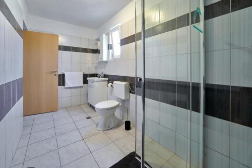 uma casa de banho com um WC e uma cabina de duche em vidro. em apartment doris em Bibinje