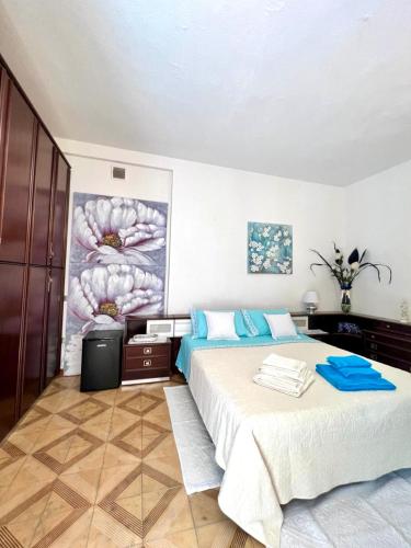 a bedroom with two beds and a painting on the wall at Casa Giada in Villasimius