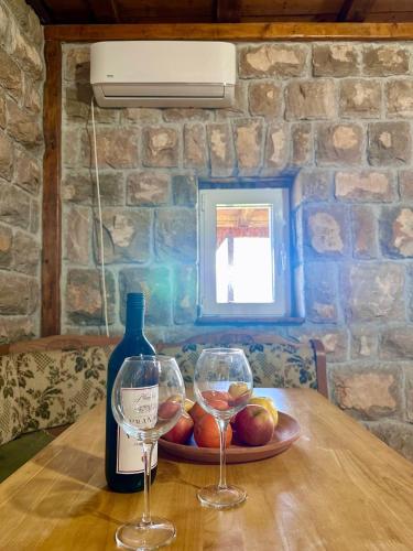 a bottle of wine and two wine glasses on a table at Martina in Cetinje