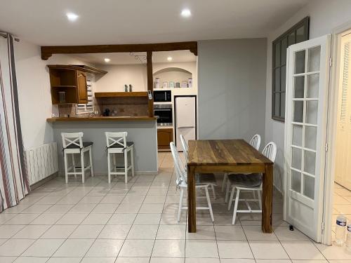 - une cuisine avec une table et des chaises en bois dans la chambre dans l'établissement Maison cosy avec piscine, à Saleilles