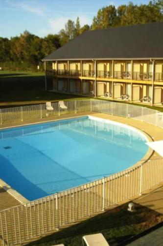 une grande piscine bleue devant un immeuble dans l'établissement T3 4 à 5 pers 4km Honfleur piscine, à Équemauville