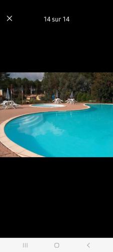 une photo d'une grande piscine bleue dans l'établissement Village Océlandes - Maison à St Julien en Born - Landes, à Saint-Julien-en-Born