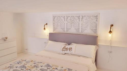 - une chambre avec un lit muni d'un signe d'amour dans l'établissement La Perla Blu, à Calasetta