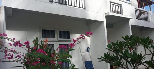 ein weißes Gebäude mit rosa Blumen davor in der Unterkunft Sahan Villa in Sri Jayewardenepura Kotte