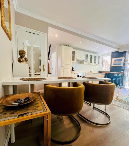 une cuisine avec une table, des chaises et un comptoir dans l'établissement Superbe appartement avec Terrasse Jardin et Parking privé, à Saint-Tropez