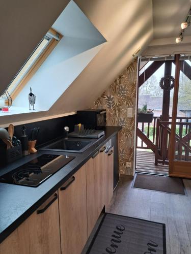 Il comprend une cuisine équipée d'une cuisinière. four supérieur à côté d'une fenêtre dans l'établissement O loft des Croisiens, à Saint-Quentin-Lamotte-Croix-au-Bailly