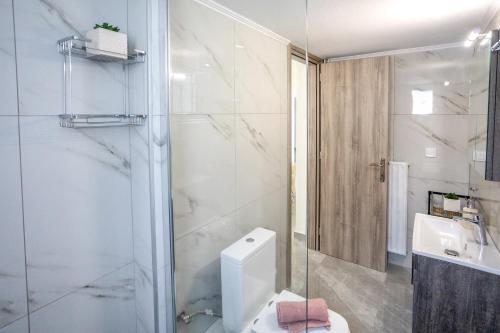 a bathroom with a shower and a toilet and a sink at House & Garden in Kavála