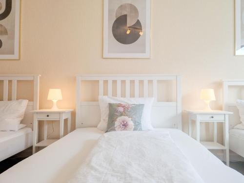 希爾德斯海姆的住宿－Apartment am Dammtor，一间卧室配有一张带两盏灯的大型白色床。