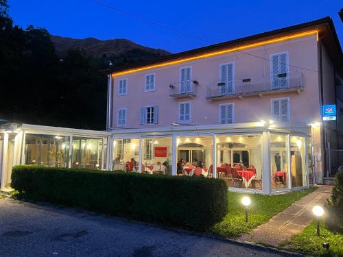 een groot wit gebouw met 's nachts tafels en stoelen bij Val Colla B&B in Lugano