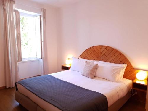 a bedroom with a bed with two lamps and a window at Val Colla B&B in Lugano