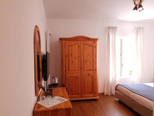 um quarto com uma cama, um armário de madeira e uma mesa em Val Colla B&B em Lugano