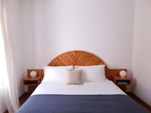 een slaapkamer met een groot bed met een houten hoofdeinde bij Val Colla B&B in Lugano