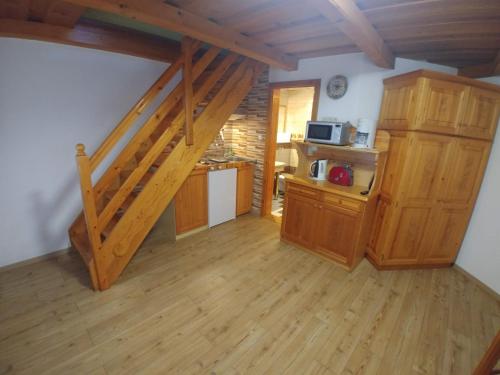 a kitchen with wooden floors and a staircase in a room at Zöld sziget Apartmanház in Gyenesdiás