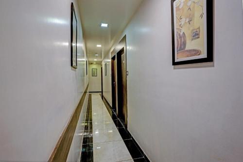 a long hallway with white walls and a tile floor at OYO Hotel Blue Inn Residence Near R City Mall in Mumbai