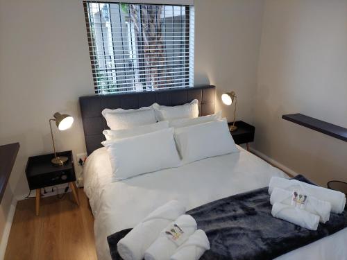 a bedroom with a large white bed with towels on it at Pentz View in Cape Town