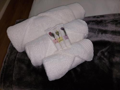 two towels with flowers on them on a bed at Pentz View in Cape Town