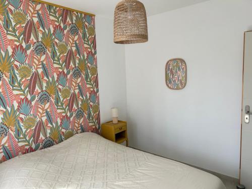 - une chambre avec un lit à tête fleurie dans l'établissement L'ombre du tilleul, à Saint-Maurice-sur-Eygues